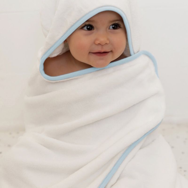 imagem de um bebê enrolado em uma toalha de banho com capuz Donna Laço Bebê